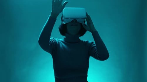 Woman Using VR Headset in Teal Lit Room
