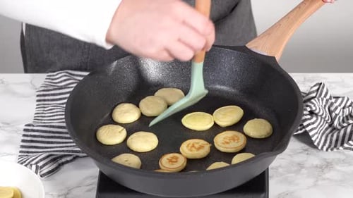 Schritt für Schritt Mini-Pfannkuchen-Müsli in einer antihaftbeschichteten Pfanne braten