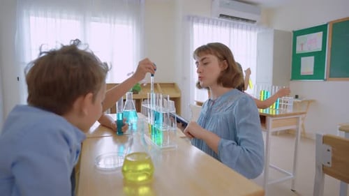 Adorable student learn with teacher in classroom at elementary school.