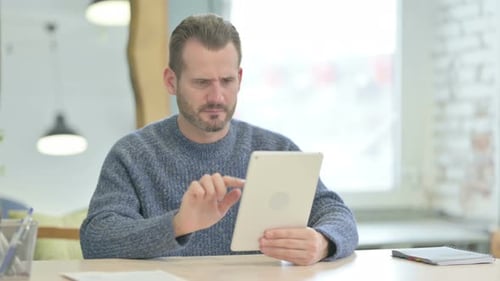 Stressed Man Using a Tablet at Work