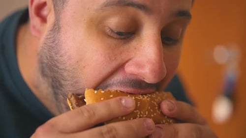 Close-up shot eating a hamburger at home