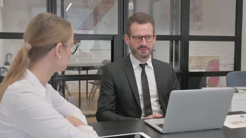 Business Colleagues Discussing Data in a Modern Office