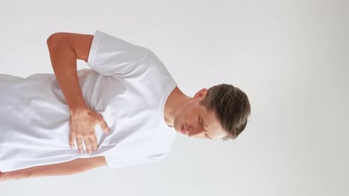 Man Holding Chest Painfully Drinks From Mug