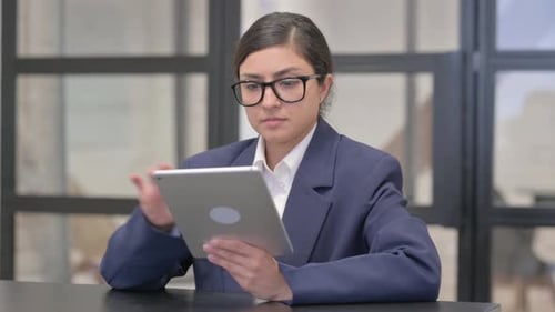 Woman Working on Tablet in Modern Office