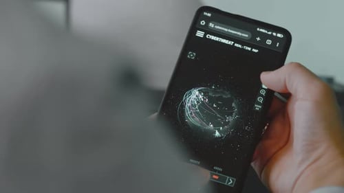 Hand Holds Phone Displaying Cyber Threat Map