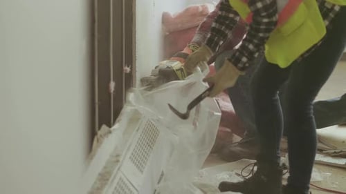 Mature woman supervising partition wall construction in empty Canada office