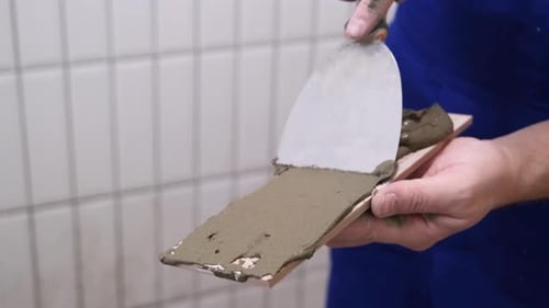 Person Applies Adhesive to Tile