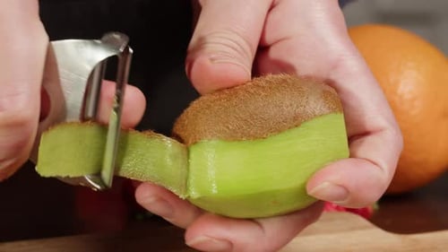 Hands Peel Fresh Kiwi Fruit Close Up