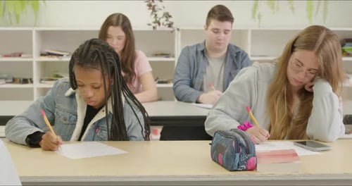 Students Learning in School Class Room. High School or College Aged Young Adults Studying & Writing