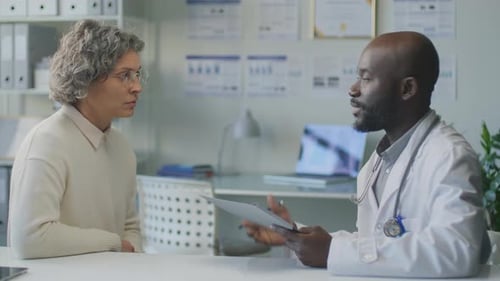 Doctor Discussing Medical Information with Female Patient in Modern Clinic