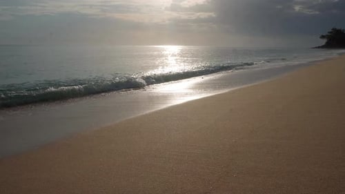 Sun Glare Reflection on Wet Beach Sand During Sunset or Sunrise