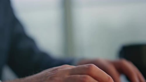 Man Typing on Laptop in Bright Office