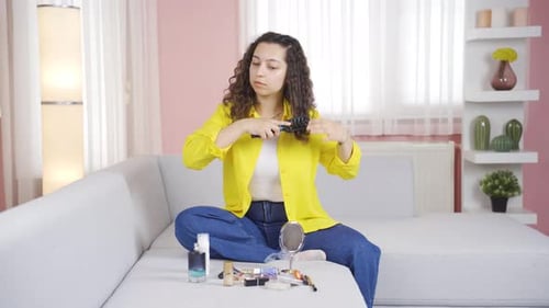 Young woman combing her hair. Hair care.
