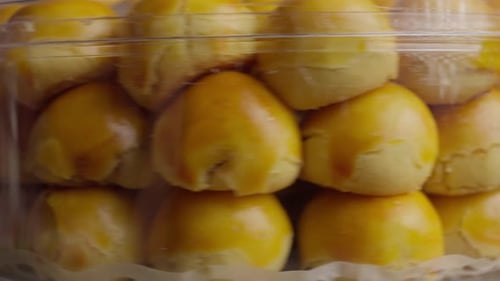 Recipiente redondo transparente con deliciosos pasteles rellenos redondos y quebradizos, Nastar y una lámina de piña indonesia