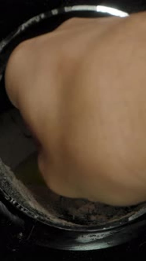 Vertical video. Man Scooping Chocolate Protein Powder with a Spoon. Dolly Zoom, Close-Up. Sports