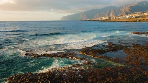 Les vagues de l'océan s'écrasent sur la plage volcanique de Rocky Shore