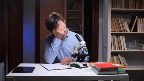 Male Using Microscope in a Research Environment