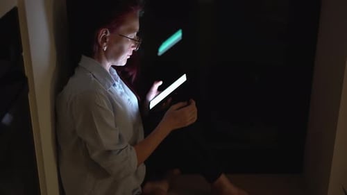 Woman Using Tablet at Home in the Dark