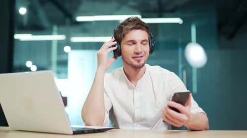 Young Adult Listening to Music in Office