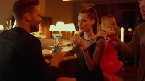 Couple Drinking Cocktails In Bar At Evening. Happy Friends Clinking Glasses In Restaurant. Smilin...