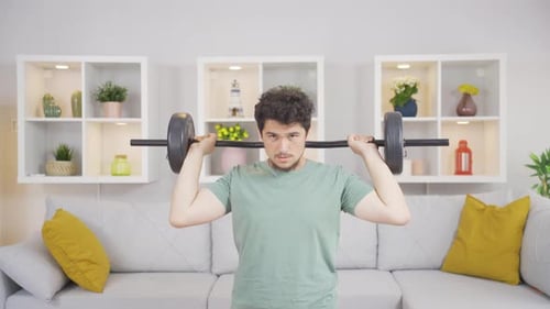 Young Man Lifting Barbell During Home Workout