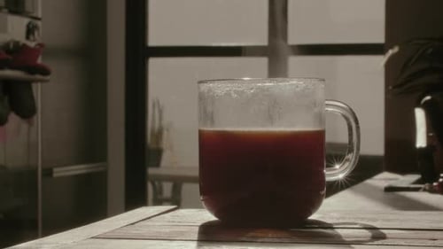 Close-up of Steaming Coffee Cup on Wooden Table