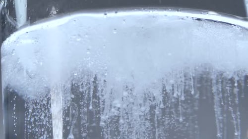 Luftblasen steigen von der Wasseroberfläche auf. Kohlensäurehaltiges Wasser