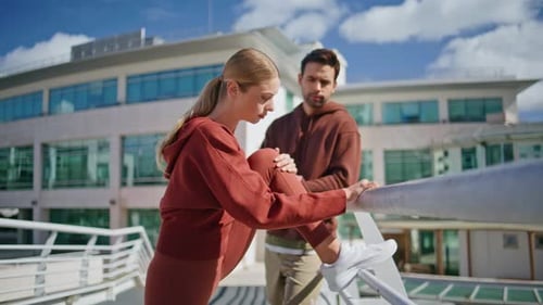 Woman Stretching Leg with Partner in Urban Setting