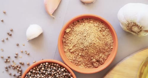 Spices, herbs and powder on table in kitchen for cooking, food or seasoning collection with garlic