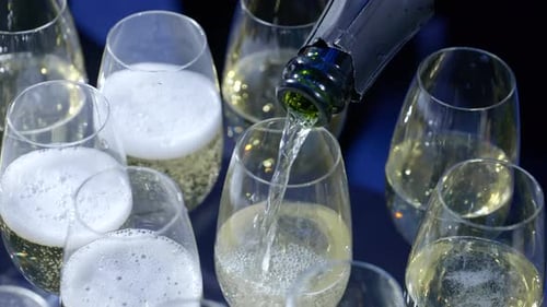 Pour champagne into champagne glasses in preparation for a celebration party in Slow motion, Circlin