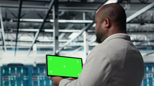 Admin Working in Server Farm Using Isolated Screen Tablet to Analyze Data