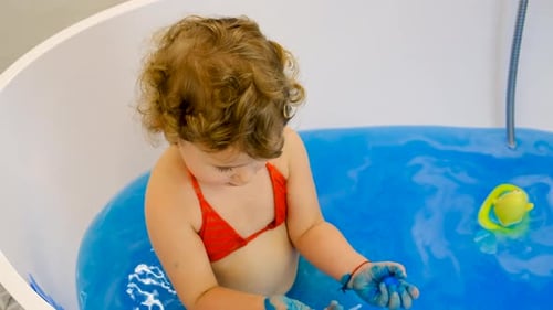 The Child Bathes in the Bath Paint Blue Color