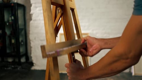 Close Up in an Art Studio an Artist Adjusts Tripod to the Desired Canvas Format