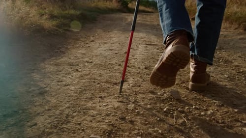 Nahaufnahme Mann in Wanderschuhen, der auf der Bergstraße spaziert. Rückansicht Männlich