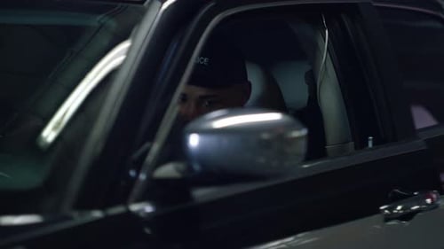 Focused Police Officer with Gun in Car at Night