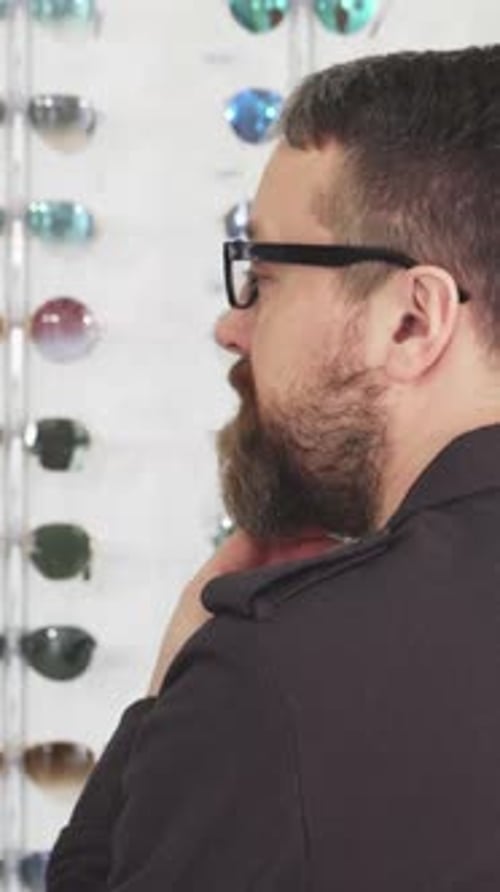 Mature Man Joyfully Selecting Stylish Glasses at the Eyewear Store