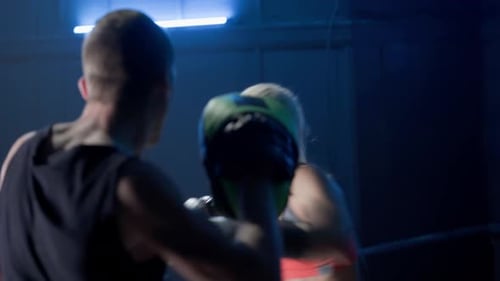 Athletic Woman Boxing with Trainer in Gym