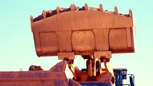Loader Unloading Pile of Dirt into Dump Truck