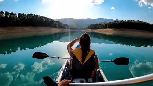 Kayakers couple kayaking rowing on kayak at lake on a scenic nature destination