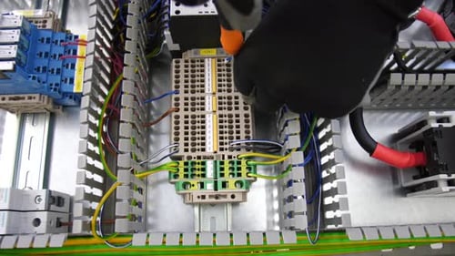 Electrician Assembling Wiring in Industrial Electrical Panel