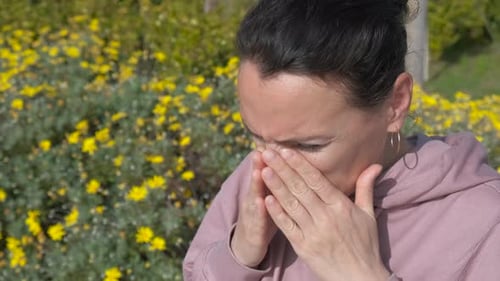 Woman with Seasonal Allergies Sneezing Outside