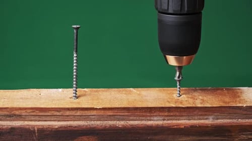 CloseUp of Unscrewing the Screw From a Block of Wood With a Screwdriver
