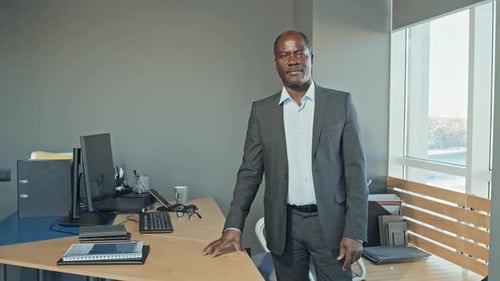 Porträt eines schwarzen männlichen Geschäftsmannes, der im Büro vor der Kamera posiert