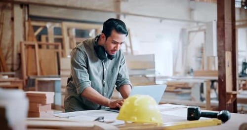 Carpentry, typing and man with laptop in workshop for woodwork order, design review and inventory