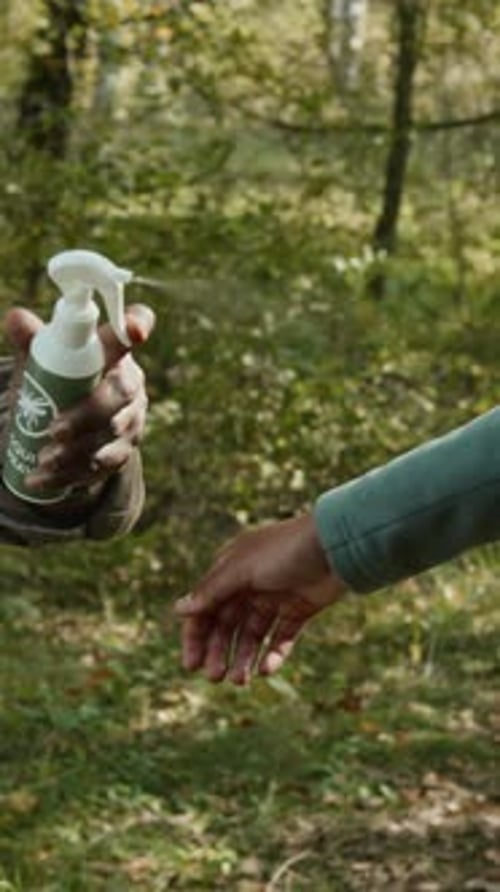 Unrecognisable Dad Spraying Mosquito Repellent on Child during Forest Hike