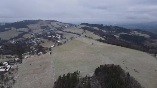 A flight over the countryside with a path leading through the trees and a view of the surrounding th