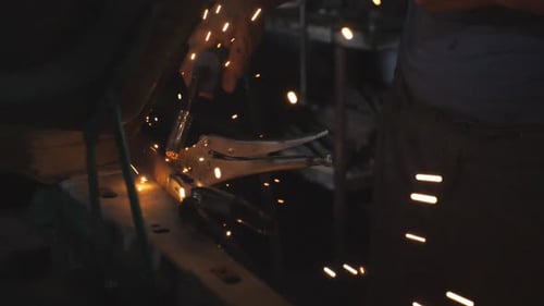 Man Using Welding Machine with Bright Sparks
