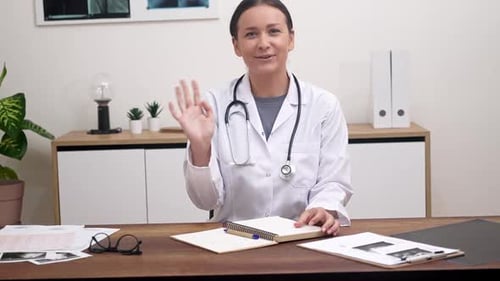 Woman Doctor Waving in Medical Office