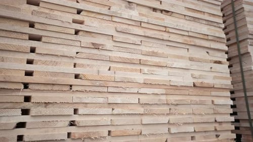 Stacked wooden planks at a construction site. Natural timber boards for building industry.