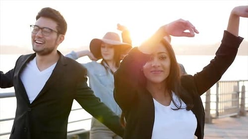 Grupo diverso de jóvenes bailando juntos afuera al atardecer